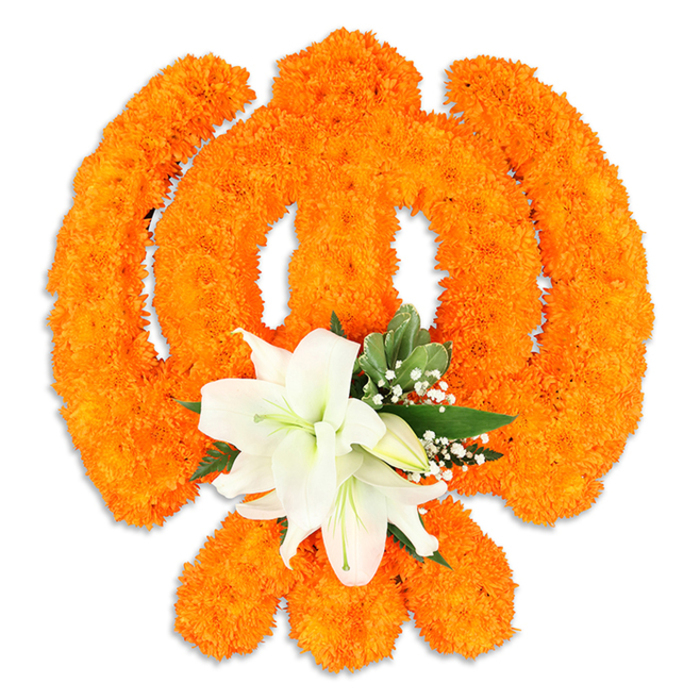 This striking floral depiction of the Khanda is assembled with traditional materials and a modern florist's eye: a dense field of bright orange marigolds forms the symbol's essential lines-the circular chakkar, the two crossed kirpans and the upright double-edged khanda-each segment carved out in rich, textured blooms that appear almost sculpted beneath the studio lights. Near the centre, a composed cluster of white lilies offers a serene contrast; at least two fully opened lilies display their slightly recurved petals and hands of green-and-yellow stamens, surrounded by several smaller buds waiting to open. The marigolds' compact fluffiness creates a tactile, celebratory surface while the lilies bring quiet grace. Small white filler flowers-likely baby's breath-dot the borders between orange and white, and glossy green foliage, possibly salal or similar leaves, is used to outline and lift the form, adding dimensionality and a cool, natural counterbalance to the warm orange. A delicate drop shadow beneath the arrangement emphasizes its freestanding presence, suggesting it was made as an offering or focal decoration for a gurdwara, community celebration, or a commemorative event. The visual language here reads of devotion and communal pride; anyone in Queensbury or neighbouring Wembley could recognise the care in its construction and the symbolism it carries. The overall mood is respectful and celebratory, a floral tribute that communicates both the vibrant joy of marigold and the calm dignity of white lilies.