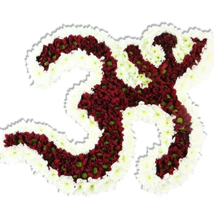 Against an immaculate white backdrop this floral Om (Aum) reads like a reverent icon fashioned from living petals. The symbol's primary mass is composed of densely arranged dark red or maroon chrysanthemum-style pompons; their compact, many-layered petals create a rich, velvety surface that absorbs light and lends sculptural weight. Notice how each of those small blooms bears a tiny lime-green centre-natural punctuation that lends a subtle, organic variation to the deep red field. A substantial border of pristine white spray chrysanthemums undulates around the interior, delineating the negative spaces and accentuating the iconic '3'-curve, the flowing descending stroke and the crescent-and-dot motif. That white rim brightens the design and produces a striking chiaroscuro effect between the interior and the surrounding white plane. The soft, diffused illumination highlights petal texture and casts a gentle shadow beneath, reinforcing the arrangement's three-dimensional craftsmanship.
As a hands-on florist who has crafted tributes for community temples and cultural events in and around Queensbury and neighbouring Wembley, I think of this piece at a ceremonial table or reception for spiritual observance. It communicates calm, solemnity and devotion-equally suitable for a guided meditation, a cultural celebration, or a dignified memorial. The tactile density, the careful colour balance between maroon, lime and white, and the exacting placement of each bloom reflect hours of meticulous work and floral expertise, offering a solemn and beautiful floral rendering of one of the most potent spiritual symbols in Hindu, Buddhist and Jain traditions.