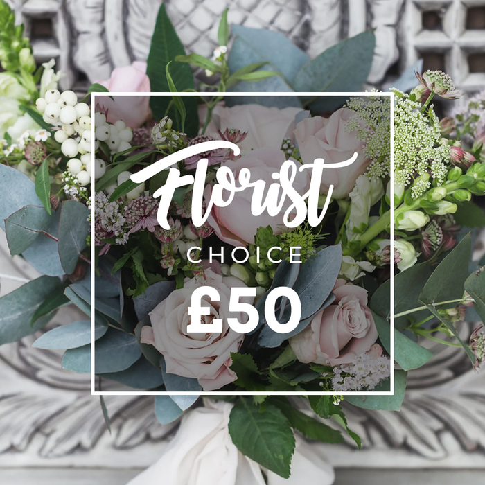 A lush, hand-tied floral bouquet is the unmistakable focus here, set before a softly blurred, ornate stone or plaster background that suggests an elegant interior. The display is dominated by soft blush pink roses with unfurling, petal-soft heads that read as romantic and refined; they are surrounded by abundant dusty blue-green eucalyptus, whose rounded leaves offer a cool, muted counterpoint. Bright white berries-reminiscent of hypericum or snowberries-dot the arrangement and catch the eye, while sprays of tiny white flowers, perhaps waxflower or astrantia, add an airy, delicate texture. Small deeper pink or burgundy blooms are tucked in for shadow and dimension, and taller green-and-white spikes resembling snapdragons rise at the left and right margins to give the bouquet graceful height. The stems are gathered in a loose, artisanal hand-tie, finished with a cream fabric ribbon that spills gently at the base, reinforcing the bespoke, natural aesthetic. Overlaying the image is a clean white rectangular frame with white lettering: a flowing script reads Florist, followed by CHOICE in uppercase sans-serif and the clear pricing mark ?50, signalling a curated florist's selection. This composition, photographed in soft ambient light, radiates calm conviviality-ideal for a milestone birthday, anniversary, or to welcome someone home-and is the kind of classic bouquet we prepare for deliveries across Queensbury, from the local high street to homes near Queensbury Tube. The piece reflects steady craftsmanship and a considered palette of scent and texture.