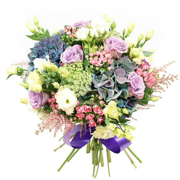 Characterized by expert balance and an artfully orchestrated palette, this bouquet bursts with vitality and grace, a true celebration of floral artistry as seen through the eyes of a Queensbury florist. The arrangement is anchored by grand hydrangeas in layered indigo, teal, and muted violet hues, echoing the lush colour schemes admired in local gardens along Stag Lane or at the edges of Roe Green Park. These central blooms are gracefully flanked by roses in soft lavender and refined creamy white, each rose displaying delicately unfurling petals in a testament to timeless beauty. Crisp, white ranunculus-lushly layered and finely textured-contrast against the hydrangeas, while slender, pale yellow lisianthus buds and partially opened blossoms stretch upward, offering a gentle luminosity similar to early morning sunlight over Kenton. Smaller clusters of brilliant fuchsia-pink blooms offer pockets of energy, with airy, blush pink astilbe plumes adding a whimsical softness and light movement around the arrangement's borders. Light green and white lacy fillers, reminiscent of wild Queen Anne's Lace, introduce quiet intricacy that weaves between the larger forms, their almost translucent quality evoking fleeting moments in local meadows. Deep green foliage underpins the display, enhancing the lush diversity. The neatly bundled stems are bound with a wide, shimmer-finished royal purple satin ribbon, a sophisticated twist that subtly reflects the cool, harmonious colour story. Perfect as a centerpiece or a thoughtful gift for birthdays, anniversaries, or special moments shared in Queensbury, this arrangement effortlessly showcases both creativity and the distinctive charm of local floristry.