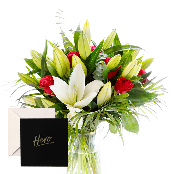 Near our Queensbury storefront, I blend the bold with the serene in this arrangement, a testament to harmony between strength and calm. White lilies drift at the heart, luminous and airy, their satin petals contrasting with a lush, forest-green backdrop of leaves. Rich ruby roses punctuate the design, each bloom a symbol of love and respect. Verdant leaves provide a cooling frame, while unopened lily buds hint at new beginnings. In soft, natural light, the bouquet feels alive and uplifting, perfect for honoring someone's strength or celebrating a major achievement. The accompanying 'Hero' card personalizes the gesture, making it intimate and enduring.
Available for delivery across Queensbury, we reach doorsteps, offices, and care homes alike, with same-day delivery to streets near the High Street and nearby parks. The contrast of crisp white and deep red, set against glossy greens, communicates courage and tenderness in equal measure. This is a timeless tribute, suitable for birthdays, promotions, or heartfelt thanks, and it travels well in a sturdy vase. The craftsmanship shows in every alignment of stem and leaf, the bouquet telling a story of admiration and resilience, a quiet homage to a local hero.