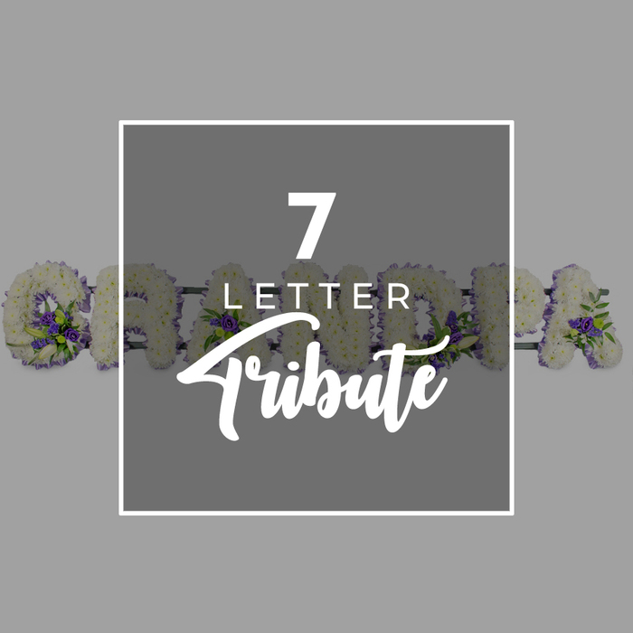 A refined memorial artwork is set on a gentle grey background, where a slightly darker grey square sits centrally, trimmed with a narrow white border that frames the design with understated elegance. Within this square sits the phrase 7 LETTER Tribute in striking white type: the number 7 appears large and bold, LETTER rests below in clear uppercase sans-serif letters, and Tribute sweeps across the lower half in a graceful script, as if handwritten with care. Just outside this graphic window, an exquisite funeral flower arrangement stretches horizontally, spelling out the seven-letter word GRANDMA. Each individual letter is crafted from tightly clustered white chrysanthemums or similar tiny-headed flowers, their rounded petals creating a plush, velvety surface that suggests gentleness and purity. Scattered thoughtfully through the letters are rich purple blooms, possibly lisianthus or small roses, mingled with touches of glossy green foliage that add dimension and an almost garden-like freshness. You can clearly make out sections of the 'G' and the closing 'A', while the middle letters recede slightly behind the central square, giving a layered, almost three-dimensional feel. The tribute feels as if it has been created by careful local hands for a Queensbury family, perhaps to be delivered to a quiet service near Kingsbury Road or along the residential streets leading from Queensbury Circle. The atmosphere of the image is calm and respectful, capturing the way a bespoke seven-letter tribute can honour a beloved grandma with both visual beauty and deep emotional resonance, offering comfort to those gathered in farewell.