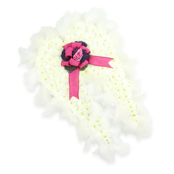 This photograph presents an exquisitely detailed floral tribute shaped as a full pair of angel wings, resting against a seamless white backdrop so that the form and texture become the focus. Each wing is filled edge to edge with tiny white chrysanthemums or similar small-headed blooms, arranged so tightly that they form a smooth, cloud-like surface, with just a whisper of soft green in their centres to lend natural realism. Around the outer edge, the florist has added a fringe of fluffy white feathers, each one catching invisible light and softening the outline, as though the wings might lift at any moment. At the point where left and right wings come together, a lush satin bow in a rich fuchsia pink is tied with multiple loops and flowing tails that gently spill over the flowers. Cradled in the knot of the bow lies a single pink rosebud, perfectly shaped and not yet fully open, a tender emblem of love and remembrance. Just beneath it, short stems of dark purple or blue thistle-like flowers add texture and a jewel-toned contrast that draws the eye. The tribute feels both angelic and deeply human, the kind of custom design that might be delivered to a Queensbury funeral home or a quiet service near the green spaces around Canons Park. It reflects the calm, reverent atmosphere of a farewell, translating unspoken emotions into petals, feathers, and carefully considered colour, a comforting presence created by a florist who understands the sensitivity of local families in times of loss.
