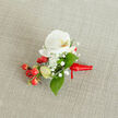 A close-up, top-down view of an elegant floral boutonniere resting on a softly textured, light beige linen background, the kind of neutral fabric you might find on a rustic table in a Queensbury High Street café. At the heart of the design sits a pristine white Phalaenopsis orchid bloom, its broad, velvety petals unfurling in a gentle oval and catching the natural light. The orchid's throat glows with a subtle wash of creamy yellow and soft orange, adding warmth and depth to the otherwise snowy white flower. Clusters of tiny, cloud-like white baby's breath surround the central bloom, their airy, star-shaped florets creating a delicate halo and softening the outline of the piece. Nestled beside them is a vivid splash of colour: glossy, cherry-red berries, round and plump, suggesting seasonal hypericum and adding a festive, almost wintry touch that would feel at home at a Kingsbury or Queensbury holiday celebration. A few paler green, oval buds peek through, hinting at freshness and new growth. Lush green leaves in varied shapes-some broader and pointed, others slim and tapering-fan out around the flowers, framing the orchid and berries with a rich, natural contrast. At the base, the stems are neatly bound in a smooth, deep red satin ribbon, wrapped tightly and finished with a small, confident knot, making the piece look ready to be pinned to a groom's lapel or worn at a prom near Queensbury underground station. The overall mood is one of refined celebration, combining crisp white, classic green, and joyful red into a small but striking floral accessory.