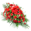 A lavish red funeral spray stretches across a white background, its elongated, gently tapered shape suggesting it is designed to rest along a casket or serve as a main tribute at a memorial. At its heart, velvety red roses cluster closely together, showing different stages of bloom-from tightly furled buds to fully open flowers with soft, spiralling petals that catch the light. Spiralling around them are abundant red carnations, their ruffled edges lending a cushioned, comforting texture, while several red gerbera daisies, with their flat, open faces and dark centres, rise slightly above the rest like bright beacons of remembrance. Scattered throughout the red blooms are delicate white filler flowers, likely baby's breath or tiny chrysanthemums, adding small, star-like touches that break up the intensity and bring depth and dimension. Near the top of the spray, a large, glossy red satin bow sits proudly, its multi-looped form and long, trailing ribbons flowing gracefully down through the flowers and visually tying the entire design together. Encircling the blooms is a rich frame of greenery: long palm fronds fan out from the base and along one side, giving the arrangement its extended, one-sided profile, while smaller, darker green leaves and a few feathery, fern-like stems fill the spaces in between, creating a full, layered effect. The overall impression is one of strength, devotion, and quiet elegance, an arrangement often chosen by Queensbury families for farewell services along Honeypot Lane or at nearby chapels, where the deep red tones symbolise enduring love, respect, and a heartfelt goodbye.