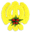A striking, hand-assembled floral Khanda rendered in a warm, sunlit palette sits against a crisp white backdrop, its sculpted form unmistakable. The entire Sikh emblem - the circular chakkar, the central double-edged khanda and the two crossed kirpans - is lovingly formed from thousands of small, tightly packed bright yellow chrysanthemums whose ruffled petals create a plush, almost velvety surface. The petals catch light softly, lending a gentle golden halo to the symbol and a subtle textured depth that reads as slightly three-dimensional against the plain white. At the very centre, where the blades and wheel converge, a compact cluster of deep red roses provides a vivid, solemn focal point: five or six buds gathered closely, their velour-like petals unfurling into a concentrated, dignified bloom. Those roses are framed by dark green fern fronds, the fine feathery foliage setting off the red and yellow in rich contrast while adding a cool, earthy scent beneath the sweeter chrysanthemum perfume. A faint grey shadow beneath the tribute hints that this is a freestanding wreath or tabletop memorial piece, ready to be placed at a Gurdwara service, remembrance event, or cultural celebration around Queensbury and neighbouring Kingsbury. The work suggests calm reverence - meticulous craftsmanship, considered colour balance and an intention to comfort. To someone who cannot see it, imagine the soft rustle of fern, the gentle, honeyed floral scent and the visual clarity of bright yellow shaped into an honoured symbol, the red roses offering a quiet note of respect in the heart of the emblem. This piece feels both traditional and lovingly contemporary in its execution, suited to community commemorations across the Brent neighbourhoods near Queensbury Tube.