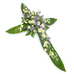 A solemn, finely crafted floral cross pictured against a clean white backdrop, seen from a slight overhead angle so the symmetrical arms and central meeting point are clearly visible. The structure is built from broad, glossy tropical leaves - think Ti leaves with visible veins and a waxy sheen - layered to form a rich green foundation that reads like protective wings around the central motif. Resting on that verdant bed is a concentrated swathe of soft white and creamy ivory blooms: ruffled lisianthus with their gently unfurling petals and tight buds, interspersed with small, rounded white chrysanthemums that catch the light and add tender texture. Sprays of tiny lavender or pale purple star-shaped flowers, likely limonium or small asters, are peppered through the composition to give a whisper of cool colour and visual depth, while fine green filler foliage threads between the clusters for subtle contrast. The lighting is even and gentle, leaving no harsh shadows so the colours read true and the tactile contrasts - smooth leaf, feathery petals - come forward. As a sympathy tribute this cross reads with composed dignity, conveying comfort, quiet faith, and the idea of remembrance; one can almost sense the faint, green-tinged scent of leaves and the delicate perfume of lisianthus. As a local florist describing it for Queensbury clients, I imagine this piece laid near a chapel at Queensbury or placed by a graveside close to Fryent Country Park - a respectful, reassuring floral memorial that speaks of hope and serenity in a measured, elegant language.
