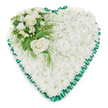 A large heart-shaped floral tribute dominates the image, meticulously formed from a thick bed of white chrysanthemums that cover the entire surface like a soft, textured blanket. Every small bloom is pressed closely to its neighbour, creating a uniform field of white that suggests innocence, peace, and a gentle farewell. Encircling the heart is a vivid emerald-green satin ribbon, folded into careful pleats that produce a scalloped frame, its slight sheen catching the light and giving the design a polished, traditional finish. In the upper left curve of the heart, a graceful accent arrangement introduces contrast and focus. Two fully opened white roses, creamy and full-petalled, sit at the centre of this cluster, symbolising enduring love and deep respect. They are supported by smaller white flowers-similar to freesias or another fine-petalled bloom-along with a scattering of buds that lend a sense of softness and progression. The roses and smaller flowers emerge from a bed of lush greenery, including broad, shiny leaves and wispy, feathery foliage that extends gently across the chrysanthemum base, adding subtle movement. Set against a pristine white background, the heart appears luminous and composed, with every detail of the flowers and ribbon clearly visible. It conveys a mood of quiet dignity and compassion, the kind of floral heart a family in Queensbury might have delivered to a local funeral home or chapel as a final tribute to someone dearly loved and deeply missed.
