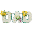 A tender, three-dimensional memorial spelled in large capital letters, 'DAD', each letter formed from a dense, cloud-like bed of pristine white spray chrysanthemums that read as soft, textured blocks when viewed from the front. The outer and inner edges of each letter are finished with a ruffled, deep green satin ribbon that frames the white blooms with a crisp, leafy contrast; thin dark-green metal support bars run horizontally behind the letters, quietly holding the three pieces together as one cohesive tribute. The left 'D' is brightened on its upper left curve by a sunlit cluster of three to four vivid yellow roses, their buttery petals set against tiny white filler blooms-likely freesias or gypsophila-and fresh green foliage, while two long, slender bare green stems arch diagonally across toward the center letter like a gentle, upward-reaching gesture.
The central 'A' carries a sober, elegant accent low on its left diagonal: two deep purple to burgundy calla lilies, their sculpted, trumpet forms offering a refined, devotional focal point, surrounded by delicate white accents and glossy leaves. The right 'D' mirrors the left with an identical cluster of yellow roses and white fillers placed on its upper right curve, creating a balanced, reassuring symmetry. The whole piece sits against a clean white background under soft, even light that emphasizes texture and shadow, and it gives off a light, fresh scent of chrysanthemums and rose. Designed as a funeral or memorial tribute, this arrangement-crafted with the care of a Queensbury florist and suitable for services around Queensbury, Kingsbury and nearby Wembley-conveys comfort, respect and remembrance through careful floral craftsmanship.