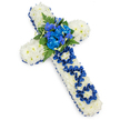 A beautifully composed funeral cross fills the image, presented on a stark white background so that its colours and textures appear especially vivid. The cross itself is built from a thick bed of white spray chrysanthemums, placed so closely together that they create a seamless, pillowy surface, each small bloom contributing to an impression of peace and purity. Around the entire edge, a rich royal blue satin ribbon has been expertly wrapped and secured, forming a defined border that enhances the cross's shape and adds a dignified, almost ceremonial presence. At the centre, where the arms of the cross meet, a striking spray of royal blue flowers forms the focal point: lush, ruffled blue carnations cluster together with more slender, sculptural blooms reminiscent of blue delphiniums or orchids. These are interlaced with deep green fern fronds and glossy leaves, their varied shapes and textures creating depth and gentle movement, like foliage stirred by a light breeze in a quiet Queensbury garden. Along the vertical section of the cross, the word DAD is delicately spelled out using the same royal blue satin ribbon, the letters carefully shaped and nestled into the white chrysanthemum base. This thoughtful touch clearly marks the tribute as a personal farewell to a father, suitable for resting beside the coffin at a chapel of rest, a church service, or a cemetery gathering around Queensbury. The overall feel of the arrangement is respectful and heartfelt, combining the calm of white flowers with the strength of deep blue to honour cherished memories and a life well lived.